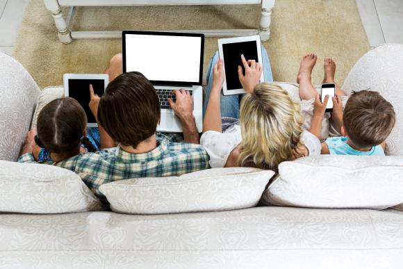 Family using devices on sofa